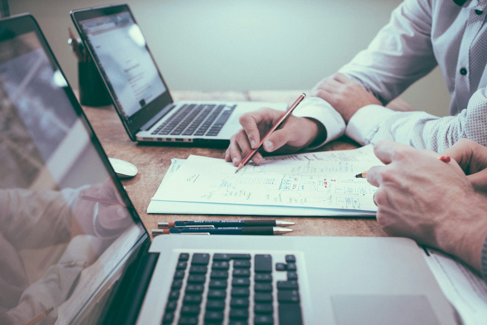 Duas pessoas analisando contratos e anotações sobre a mesa, representando o diagnóstico da dívida rural
